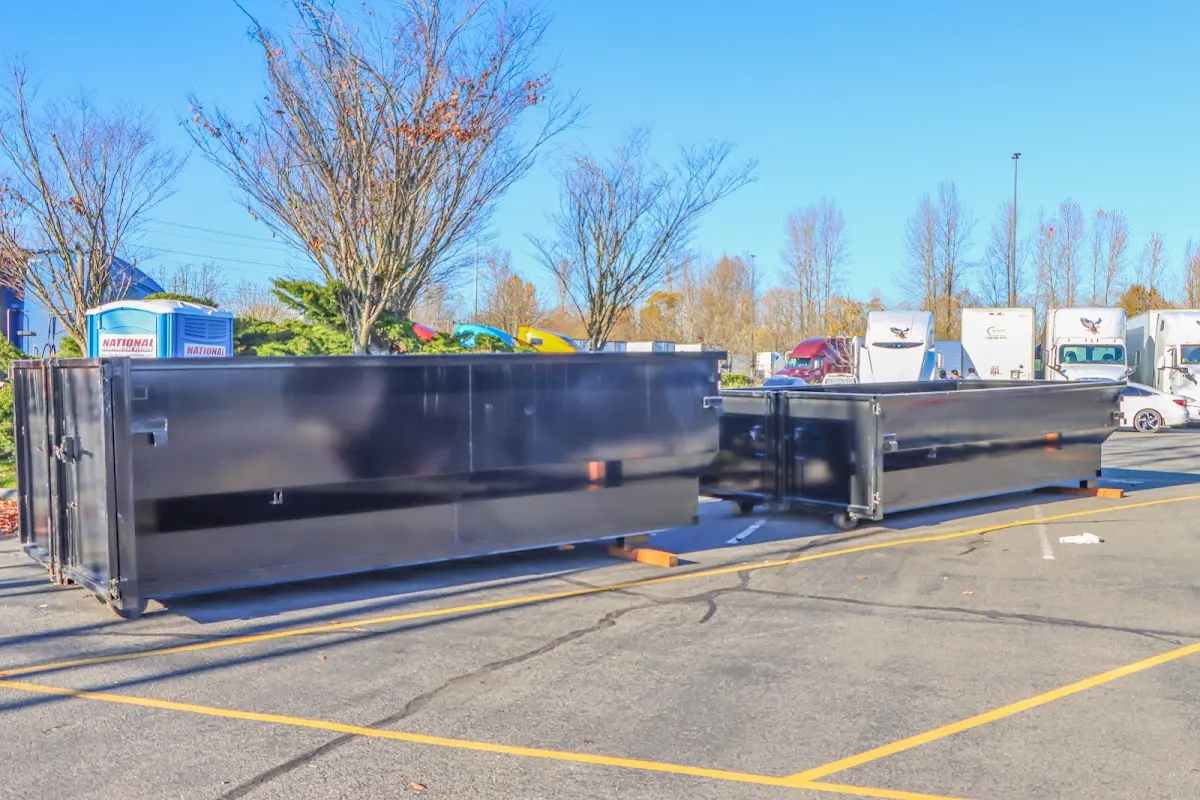 Professional dumpster rental service with roll-off container on residential driveway in Keokuk